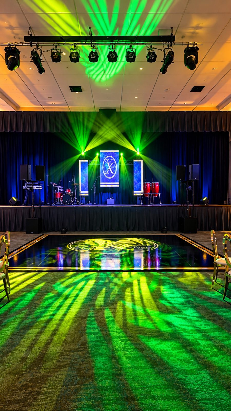 Event stage with green lighting and personalized dance floor