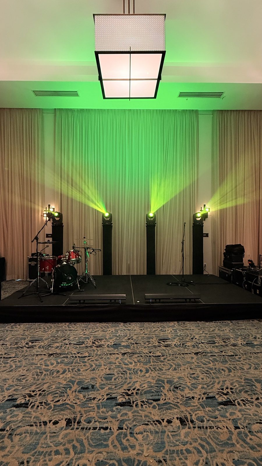 Ballroom stage with green uplighting and full production