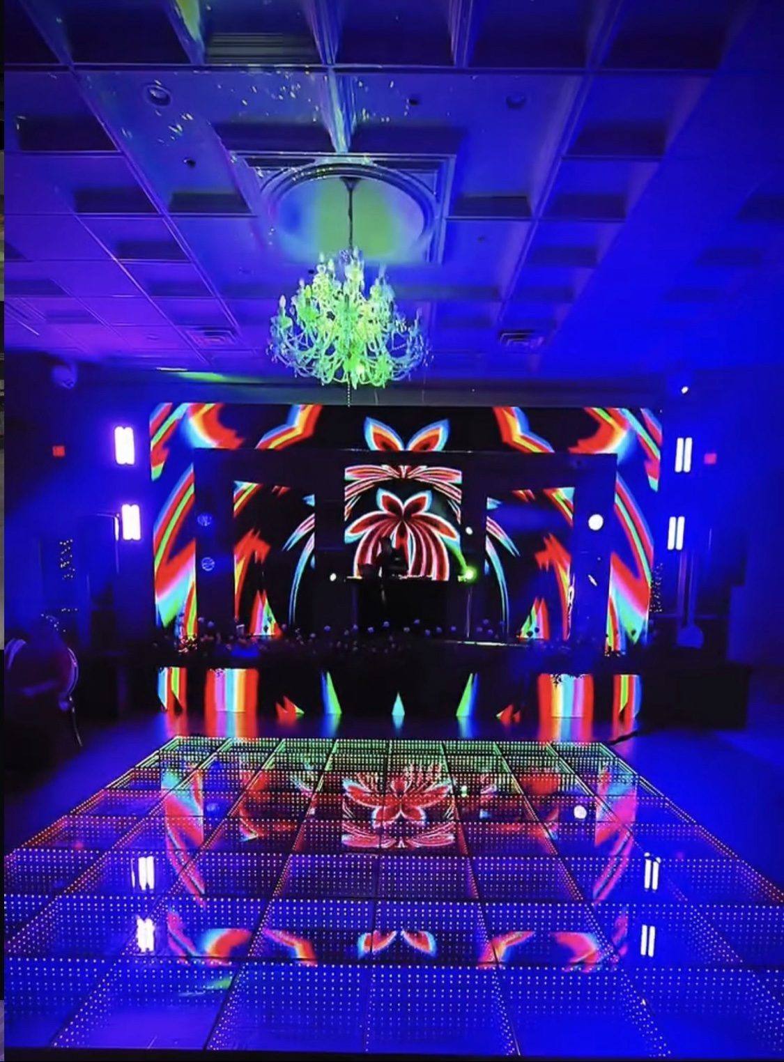 LED dance floor with vibrant palm visuals and chandelier
