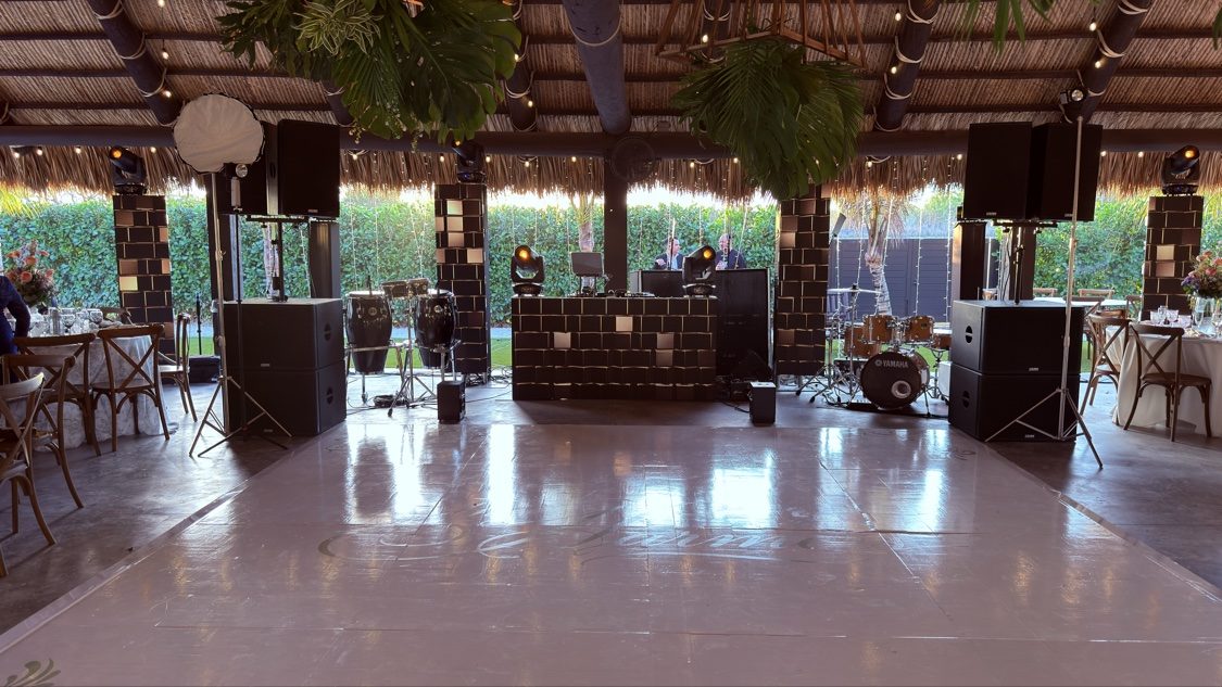 Tropical tiki hut DJ setup with mirrored booth and dance floor