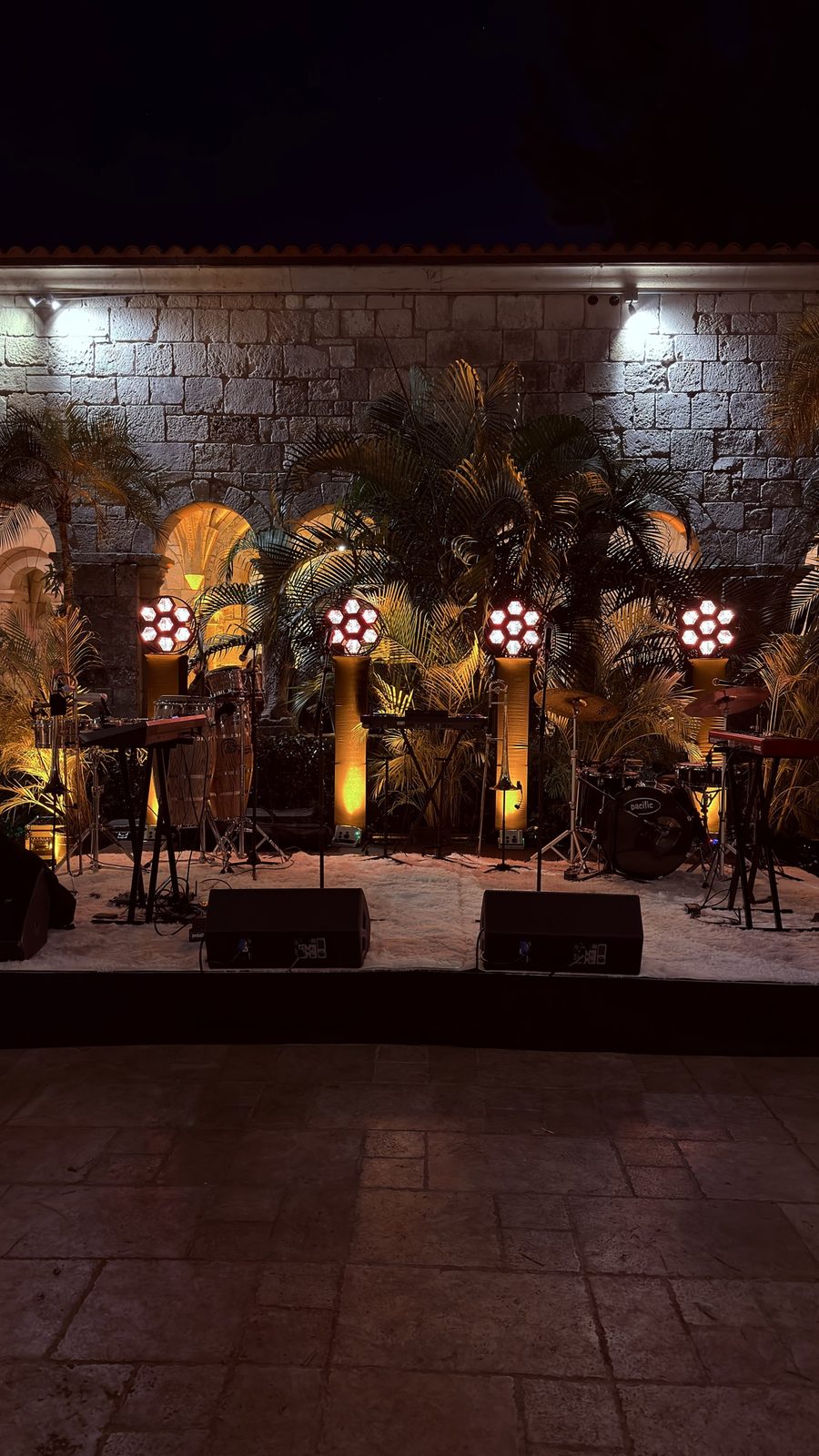 Outdoor night stage with illuminated columns and live instruments