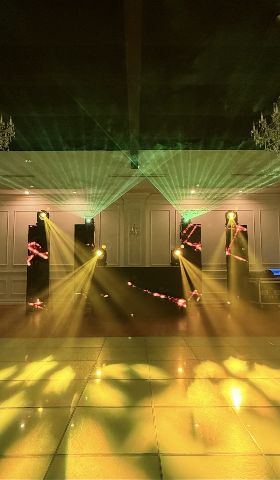 DJ booth with green laser beams and LED columns