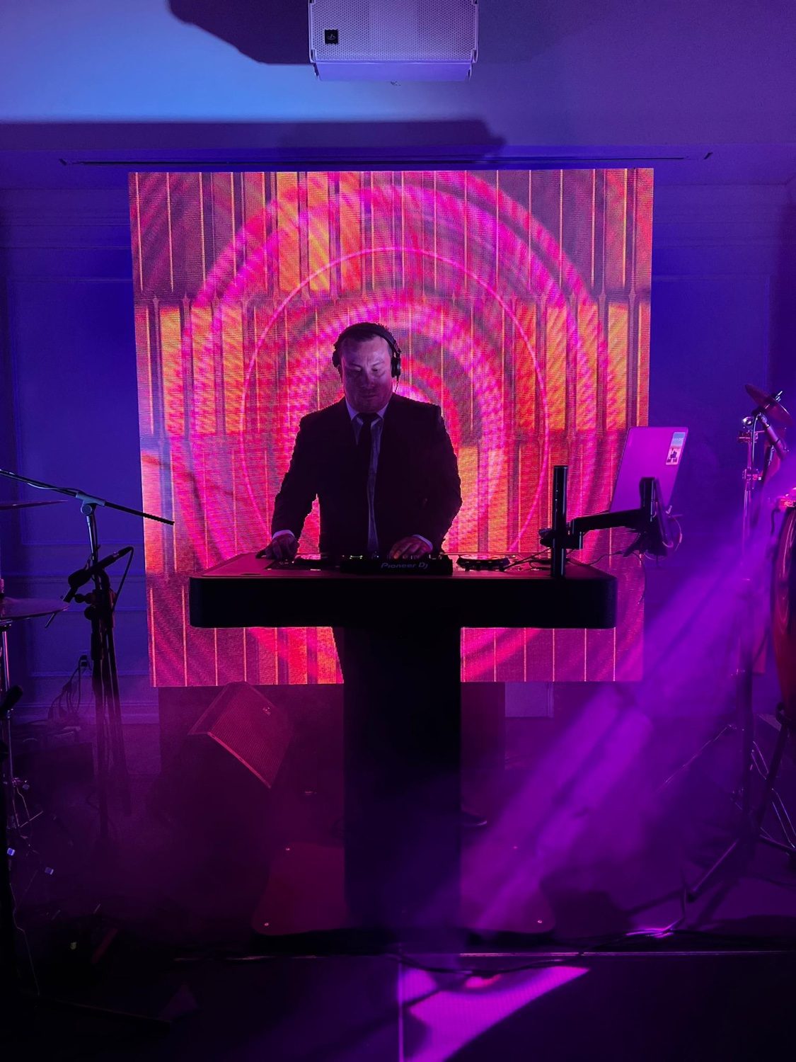 SHINNO performing live behind the decks with pink LED wall