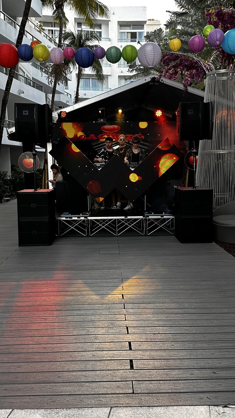 Outdoor pool party DJ setup with colorful lanterns