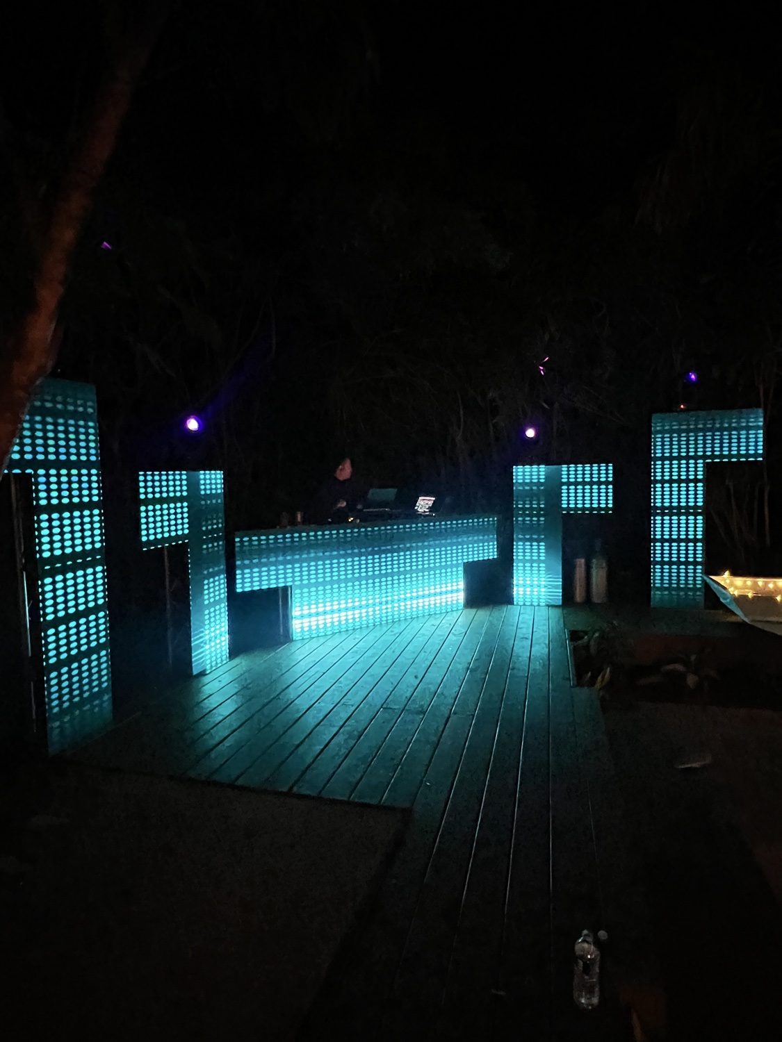 Night outdoor DJ setup with blue LED panels