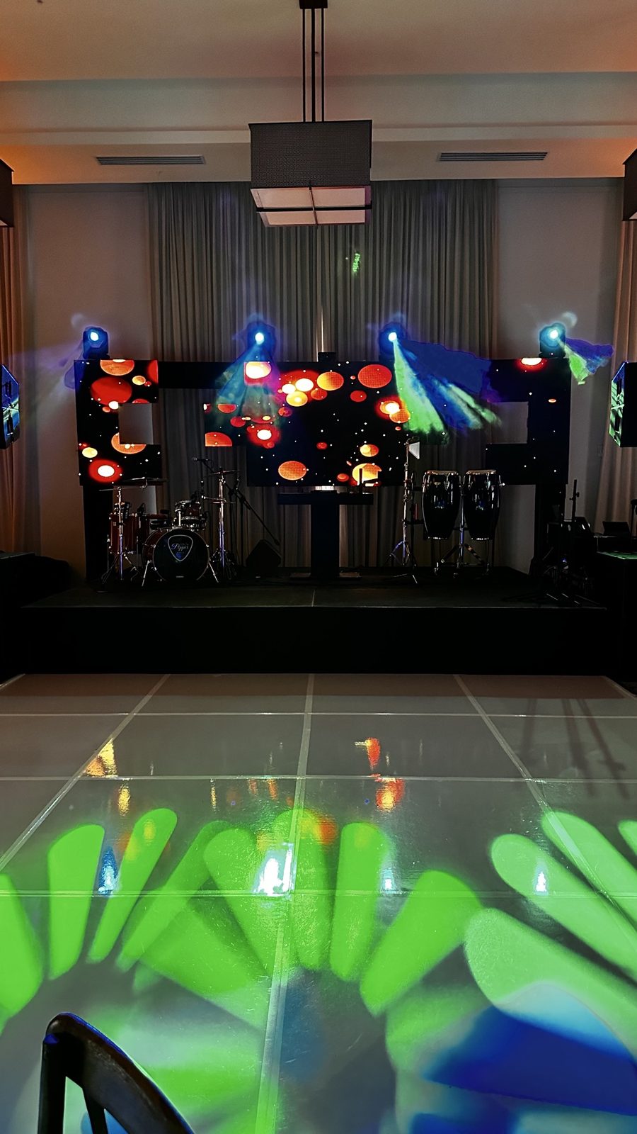 Event stage with bokeh LED wall, drums and congas